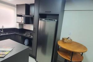 本图贡萨尔维斯Delicadeza e aconchego na Serra Gaúcha.的厨房配有不锈钢冰箱和凳子
