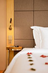 岘港Estrella Boutique Hotel的卧室配有白色的床和床头柜