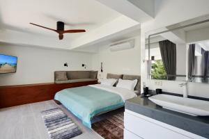 曾蒙海滩Magic suites的白色卧室设有床铺和水槽