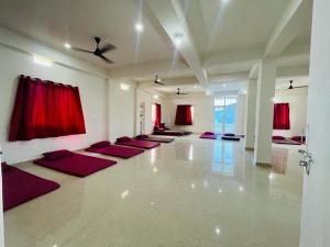 菩提伽耶Gaurav guest house的一间瑜伽室,配有红色窗帘和一排瑜伽垫