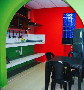 巴克里索莫雷诺港Apartamento Top House的厨房配有桌子和红色的墙壁