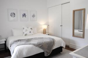 邓斯伯勒Yallingup Homestead的白色卧室配有床和镜子