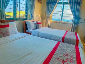 惹岛KHÁCH SẠN HƯNG THỊNH - Lý Sơn的带2扇窗户的客房内的2张床
