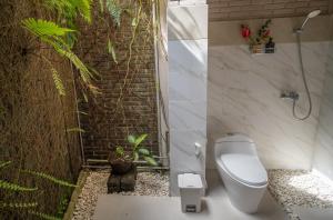 乌布普利巴育旅馆的一间带卫生间的浴室和植物墙