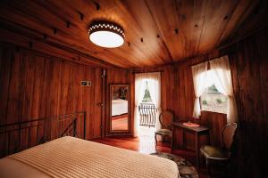本图贡萨尔维斯Pipas Terroir - Vale dos Vinhedos - Pousada Temática的木制客房内的一间卧室,配有一张床