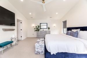盐湖城BRAND NEW Modern 5 Bd, 3 Story Home in Sugarhouse!的一间白色卧室,配有一张大床和一台电视