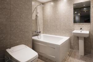 平泽市Mariposa Hotel Songtan的带浴缸、卫生间和盥洗盆的浴室