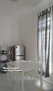 PakaHomestay Taman Tiara Paka的厨房里配有白色的桌椅