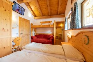 菲耶梅堡科拉迪尼食宿酒店的一间卧室配有一张床和一张红色的沙发