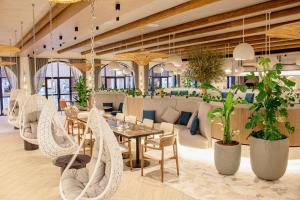 迪拜宜必思世贸中心酒店的一间设有桌椅和植物的餐厅