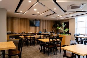 美娜多Arcadia Hotel Manado的餐厅设有桌椅和平面电视。