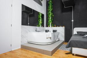 布拉迪斯拉发Wellness Apartman Vrakuna的一间带白色浴缸和床的浴室