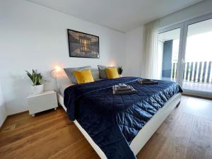海尔布隆Luxuriöses 130qm Apartment mit Balkon im Zentrum,Parkplatz的一间卧室配有一张带蓝色棉被和黄色枕头的床。