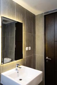 美娜多Arcadia Hotel Manado的一间带水槽、镜子和卫生间的浴室