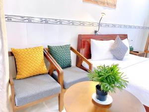 富国Have Fun Phú Quốc的一间卧室配有一张床、两把椅子和一张桌子
