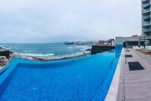圣巴托洛Departamento de Playa San Bartolo Ocean Reef - SOL, ARENA Y MAR的毗邻大海的大型蓝色游泳池
