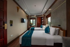 内排Hanoi Airport Hotel - Convenient & Friendly的一间卧室配有两张带蓝白色枕头的床