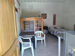 内科克利Casa Hostal Arena de Mar的小房间设有一张床、一张桌子和椅子