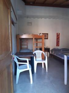 内科克利Casa Hostal Arena de Mar的配有桌子和两把椅子及一张床的房间