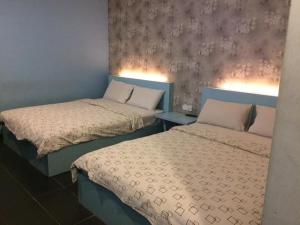 新山Kozi Hotel - Bukit Indah的两张睡床彼此相邻,位于一个房间里