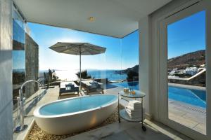 圣爱奥尼斯米科诺斯米科诺斯大酒店及度假村的带浴缸的浴室,享有海景。