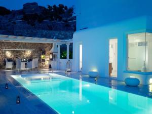 圣爱奥尼斯米科诺斯米科诺斯大酒店及度假村的蓝色灯光的房子里的一个游泳池
