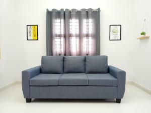 马杜赖Meadows Homestay的客厅设有蓝色沙发,配有窗户