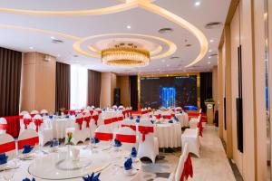 荣市Khách sạn Toàn Thắng Stone的宴会厅配有白色的桌椅和吊灯