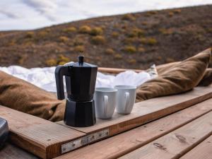 海德堡Aviary Hills Luxury Hideaway的咖啡壶和木桌上的2杯