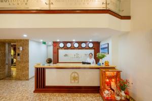 芽庄Minh Tuyết Luxury Hotel managed by HT的站在大厅柜台的女人