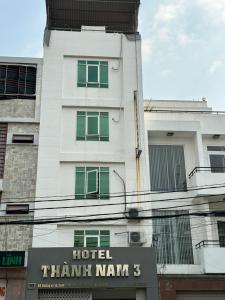 胡志明市Hotel Thành Nam 3的前面有标志的白色建筑