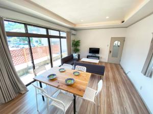 鹤冈市カモゲストハウス的客厅配有木桌和椅子