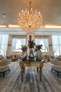 科威特科威特宏伟大酒店的一个大大堂,配有吊灯和桌子上的花瓶