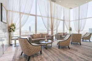 科威特科威特宏伟大酒店的带沙发和椅子的客厅以及大窗户。