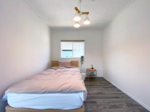 鹤冈市カモゲストハウス的一间白色客房内的床铺卧室