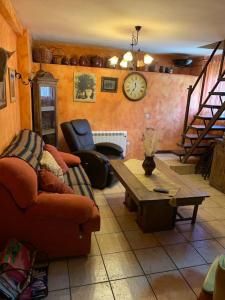 RetiendasCasa de Pueblo/Rural的带沙发、桌子和时钟的客厅