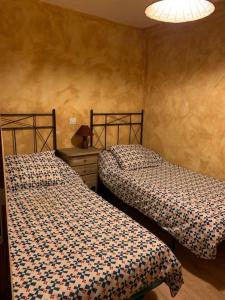 RetiendasCasa de Pueblo/Rural的一间卧室配有两张床和一张带台灯的桌子
