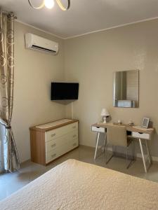 纳维廖河畔切尔努斯科CASAMAGNOLIA的一间卧室配有书桌、电视和床。