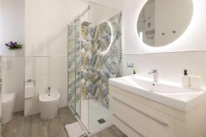 卡利亚里Quarzo. Modern Rooms的一间带水槽、卫生间和镜子的浴室