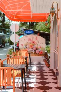 沙美岛Sidewalk Boutique Hotel的庭院配有椅子和橙色遮阳伞