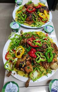 TufailahSail Alhasa Tourist Resort-Tafila的桌上有两盘带胡椒和洋葱的食物