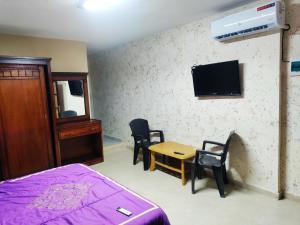 TufailahSail Alhasa Tourist Resort-Tafila的卧室配有一张床和一张桌子及椅子