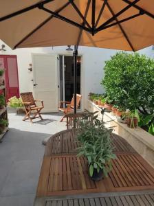 拉卡莱LA LIMONAIA的庭院设有2张长椅和遮阳伞。