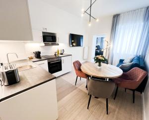 杜塞尔多夫Apartment Düsseldorf City的厨房以及带桌椅的起居室。