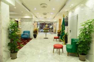 吉达Carawan Hotel Jeddah的大厅,在大楼里摆放椅子和植物