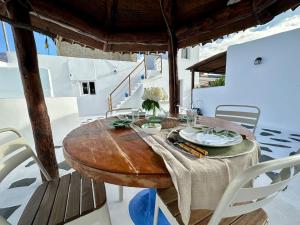 伊科德洛斯维诺斯Casa rural con piscina climatizada的甲板上配有一张木桌和椅子,配有桌椅
