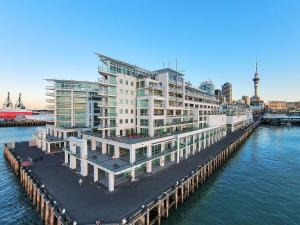 奥克兰Waterfront Seaview Hotel Apartment - same building block as Auckland Hilton的水面上一座白色的大建筑,有码头