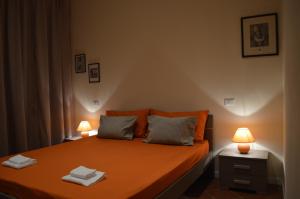 卢卡拉卡萨帝拉克莱公寓的一间卧室配有带两盏灯的橙色床