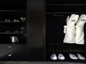奥克兰Pullman Auckland Hotel & Apartments的一间黑色厨房,配有白色的衣服和鞋子