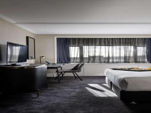 奥克兰Pullman Auckland Hotel & Apartments的配有一张床和一张书桌的酒店客房